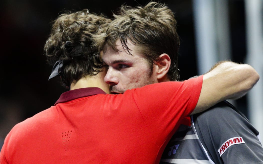 Roger Federer (L) and Stan Wawrinka embrace after their match.