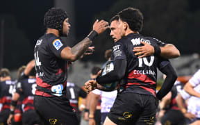 Rivez Reihana of the Crusaders celebrates with team mates after scoring a try.