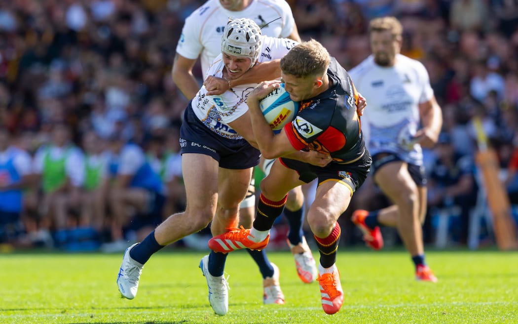 Damian McKenzie is tackled by Brumbies Declan Meredith.