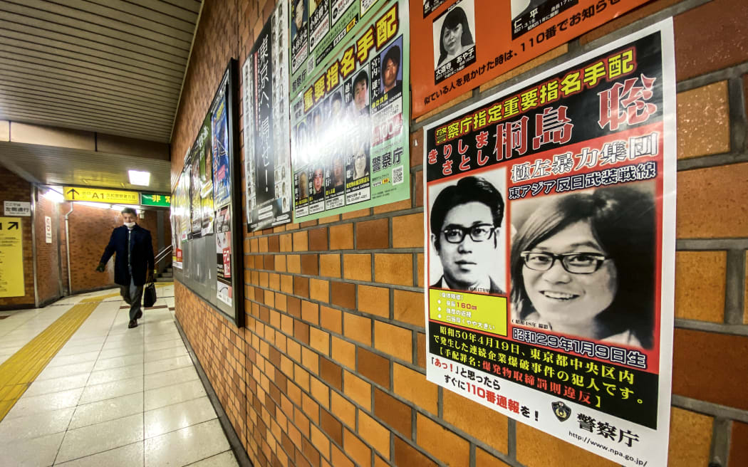 (FILES) This picture taken on January 26, 2024 in a train station of Chuo district in Tokyo shows a poster of Satoshi Kirishima, who was a member of The East Asia Anti-Japan Armed Front, a radical leftist organization responsible for bombing attacks in Japan's capital in the 1970s. DNA analysis has confirmed that 70-year-old Satoshi Kirishima who confessed on his hospital deathbed last month to being one of Japan's most-wanted fugitives was indeed the suspect, police said on February 27, 2024. (Photo by Philip FONG / AFP)