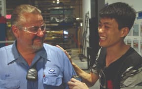 Rob Haerr and Wong He bond on the factory floor.