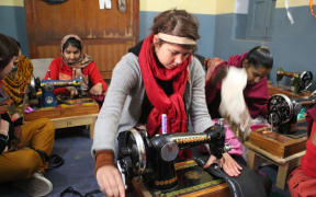 A picture of Annabel Hawkins using a sewing machine in India