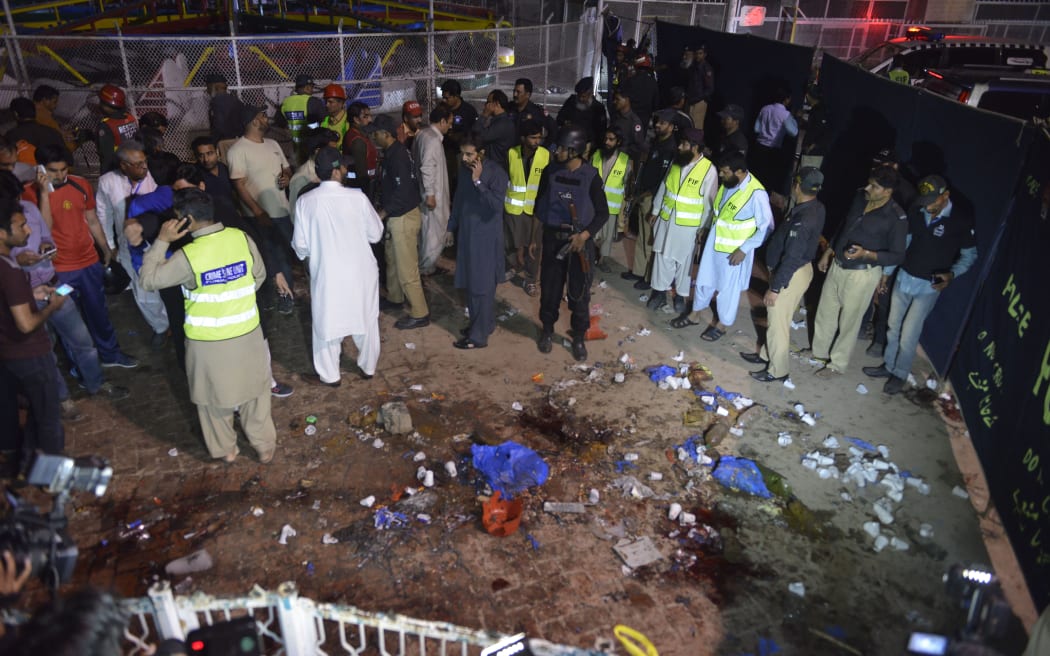 Pakistani rescuers and officials gather at the bomb blast site in Lahore.