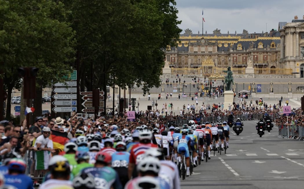 The pack of riders (peloton) cycles towards the Chateau de Versailles cycles during the men's cycling road race during the Paris 2024 Olympic Games in Paris, in Versailles, outside Paris, on August 3, 2024. (Photo by Tim De Waele / POOL / AFP)