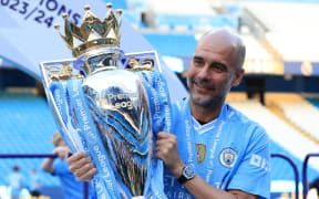 Manchester City manager Pep Guardiola poses with the Premier League trophy