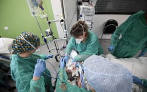Nurses tend to a Covid-19 patient at the intensive care unit of the Delafontaine AP-HP hospital in Saint-Denis, outside Paris, on December 29, 2021.