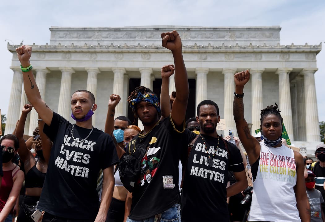 Demonstrator raise their fists at the Lincoln Memorial during a protest against police brutality and racism.