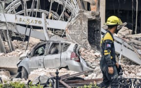 A rescuer helps after a huge blast wrecked the Saratoga Hotel in Havana on 6 May 2022.