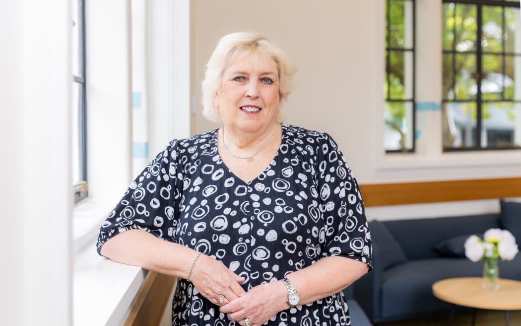Dame Margaret Brimble is sitting on a chair looking towards the camera.
