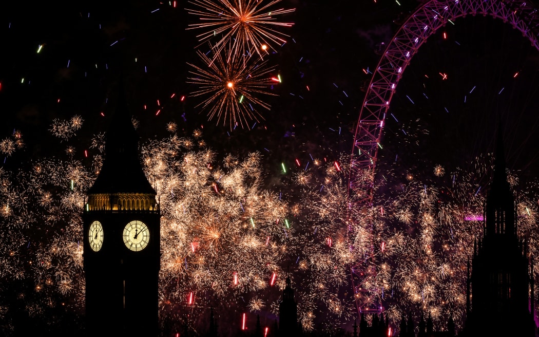Fireworks explode in the sky around the London Eye and The Elizabeth Tower, commonly known by the name of the clock's bell, "Big Ben", at the Palace of Westminster, home to the Houses of Parliament, in central London, just after midnight on January 1, 2025. (Photo by Adrian DENNIS / AFP)