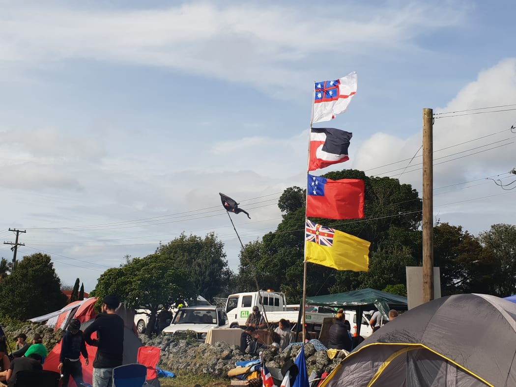 There are a range of flags on show, including (from top to bottom) the United Tribes of New Zealand flag, the tino rangatiratanga flag, the Samoan flag and the Nuienan flag, to represent the unity of all nations.