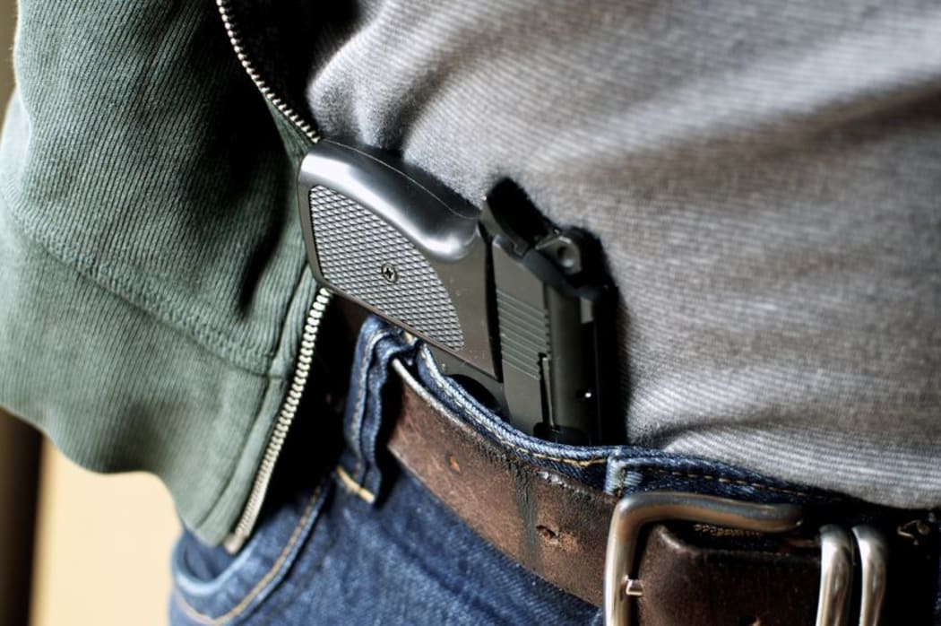 A gun concealed in a man's waistband.