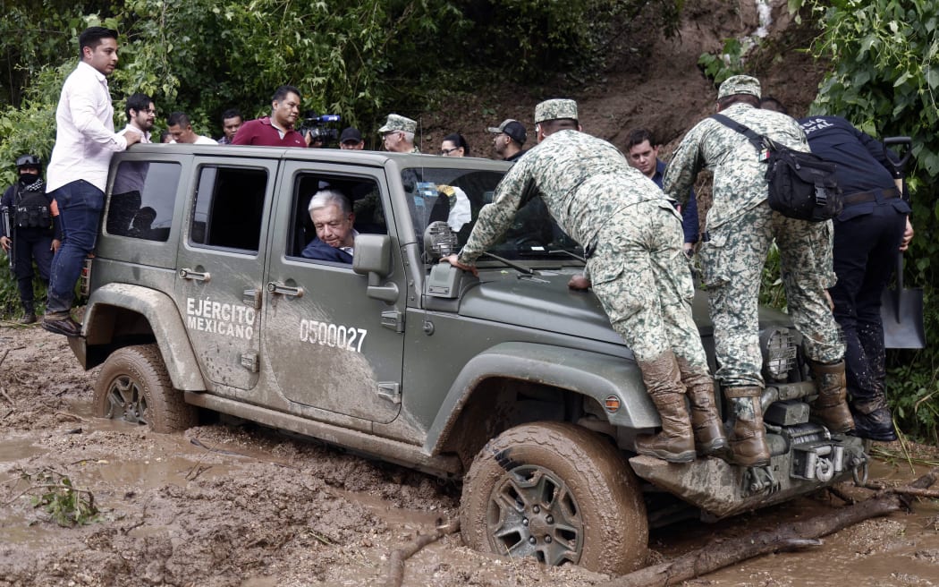 Mexican President Andres Manuel Lopez Obrador looks out of the window as the vehicle transporting him is stuck in mud during a visit to the Kilometro 42 community, near Acapulco, Guerrero State, Mexico, after the passage of Hurricane Otis, on 25 October, 2023.