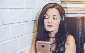 Biometric verification. Modern young woman with the phone. The concept of a new technology of face recognition on polygonal grid is constructed by the points of IT security and protection