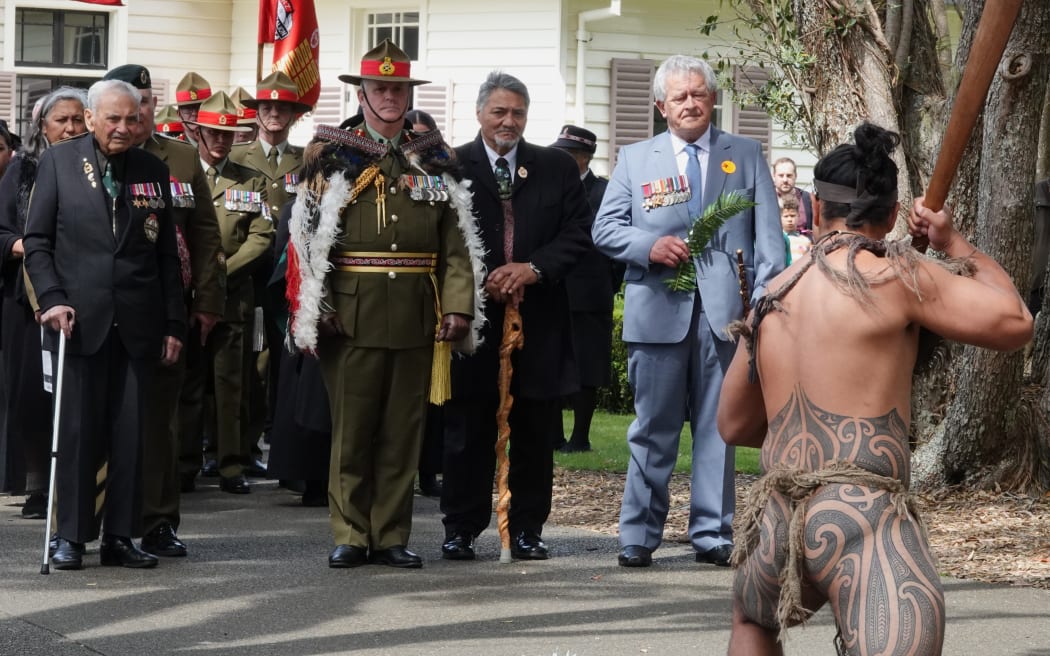 From left, Sir Robert “Bom” Gillies, Chief of Army Major-General John Boswell and Bernard Henare face the second of three challenges as they approach Te Whare Rūnanga [the carved meeting house].