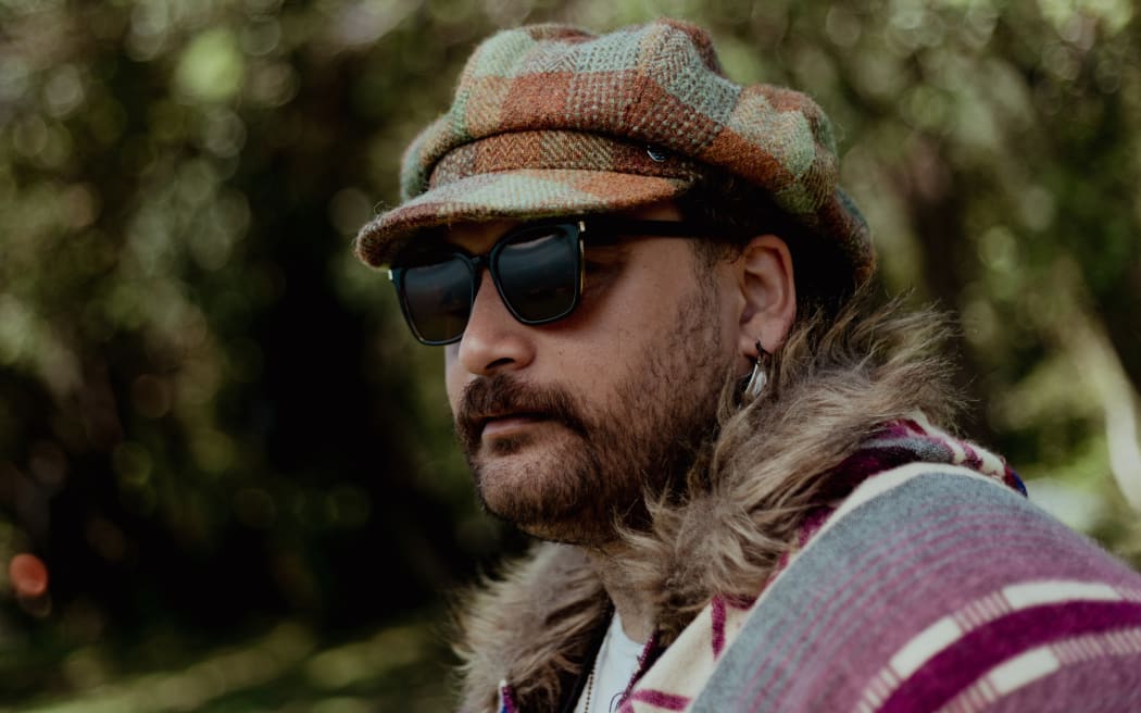 A man wearing sunglasses and a tartan hat is looking out to the left. Text reads, "Our Other Islands".