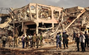 Somali security officers patrol on the scene of the explosion of a truck bomb in the centre of Mogadishu, on October 15, 2017.