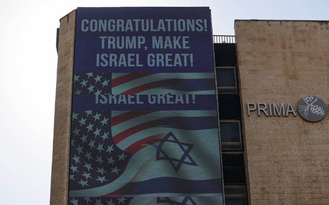 A large billboard congratulating US Republican presidential candidate and former president Donald Trump, hangs on the side of a building in Jerusalem on November 6, 2024. - Israel's Prime Minister Benjamin Netanyahu on November 6 congratulated Donald Trump, who has won the US presidential election, calling it "history's greatest comeback" and a new beginning in the US-Israel alliance. (Photo by AHMAD GHARABLI / AFP)