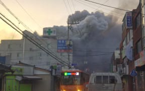 Heavy grey smoke rises into the air from a fire at a hospital building in Miryang on January 26, 2018.