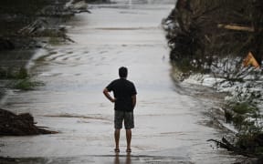 A man looks at a damaged road after severe flash flooding that occurred during the July 4 holiday weekend, in Hunt, Texas, on July 6.