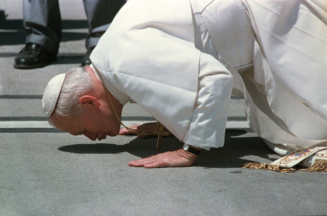 Pope John Paul II kisses the ground upon his arrival in Auckland airport on the fourth leg of a six-nation tour 22 November 1986.
