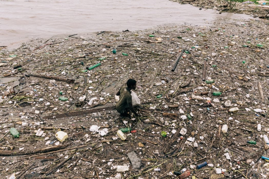 A man tries to look for items in a massive debris near the Point Yacht Club following heavy rains earlier the week in Durban, on April 15, 2022.