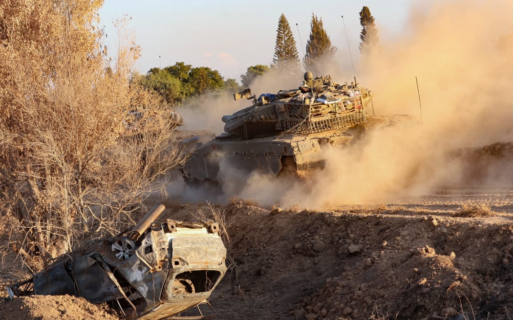 An Israeli tank moves in an undisclosed location along the border with the Gaza Strip on October 18, 2023. Thousands of people, both Israeli and Palestinians have died since October 7, 2023, when Palestinian Hamas militants in the Gaza Strip entered southern Israel in a surprise attack leading Israel to declare war on Hamas in Gaza on October 8. (Photo by GIL COHEN MAGEN / AFP)
