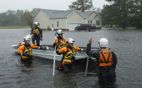 Members of the FEMA Urban Search and Rescue Task Force 4 from Oakland, California, search a flooded neighborhood for evacuees during Hurricane Florence in Fairfield Harbour, North Carolina.