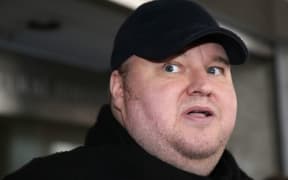 Kim Dotcom standing in front of courthouse.