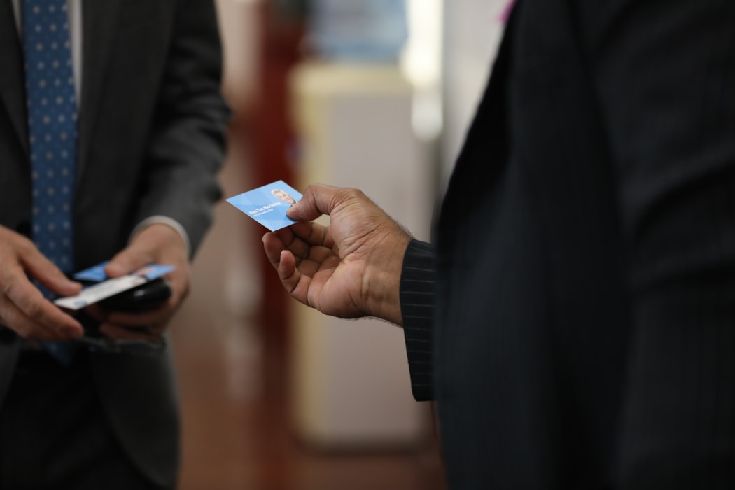 National MP Tim MacIndoe hands his business card to a Fijian MP