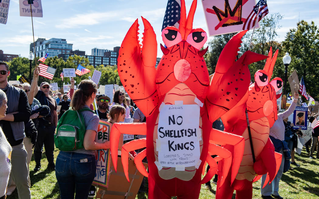 People participate in a "No Kings" national day of protest in Boston, Massachusetts, on October 18, 2025. From New York to San Francisco, millions of Americans are expected to hit the streets to voice their anger over President Donald Trump's policies at nationwide "No Kings" protests. (Photo by Joseph Prezioso / AFP)