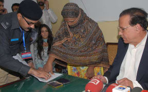 Asia Bibi, a Christian mother thums on her appeal papers against a death sentence