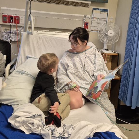 Sophia Glenn reading to her son in hospital.