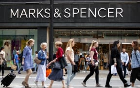 Shoppers walk past a Marks & Spencer shop on Oxford Street in central London on June 19, 2018. Major UK retailers are increasingly facing tough times in the face of intense online competition from the likes of US giant Amazon. Clothing-to-food retailer Marks & Spencer is meanwhile shutting more than 100 UK stores as it looks to shift at least one third of sales online. (Photo by Tolga Akmen / AFP)