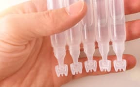 Hand with capsules of eye drops