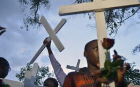 People carry wooden crosses to Freedom Corner in Nairobi in April during a gathering for the victims of an attack claimed by Somalia's Al-Qaeda-linked al-Shabaab insurgents on a university campus in Garissa, Kenya in which 148 people were killed. AFP PHOTO / TONY KARUMBA