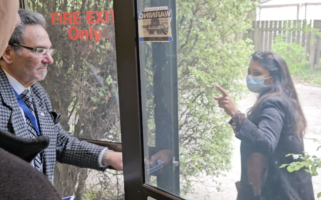 A protester is escorted out of the New Zealand First conference.
