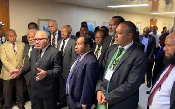 Papua New Guinea prime minister Peter O'Neill (with spectacles) flanked by coalition partners following a parliament session, 7 May 2019.