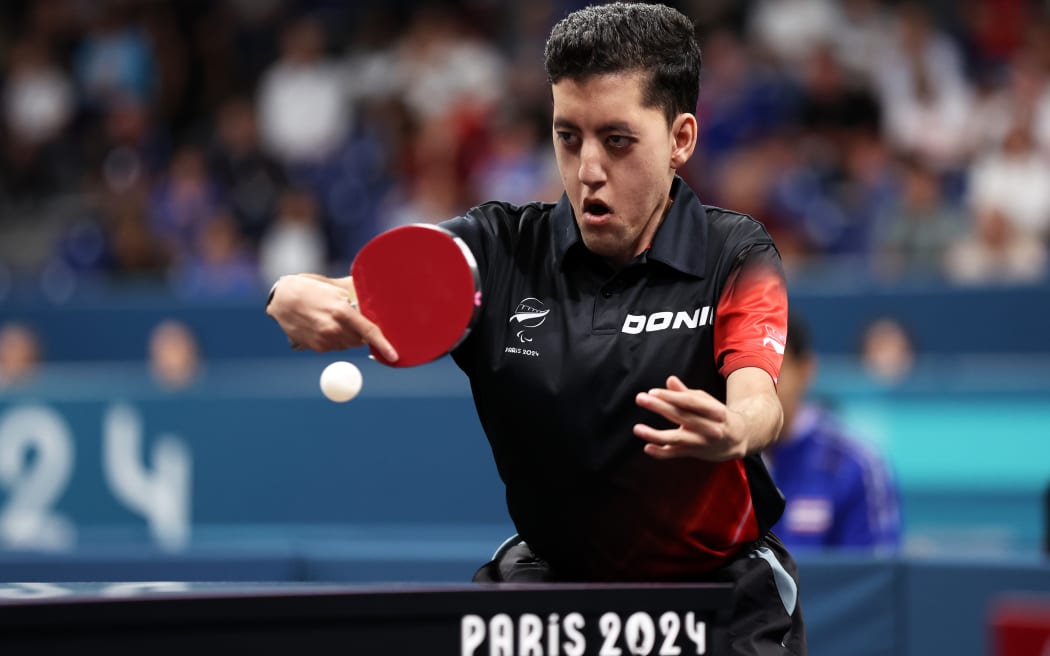 Matthew Britz of New Zealand competes against Chalermpong of Thailand in the MS7 men's singles table tennis at the Paris 2024 Summer Paralympic Games.