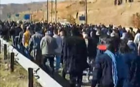 This image grab from UGC video footage made available by the Norway-based Hengaw rights group on 21 November 2022, reportedly shows Iranian protesters marching and chanting slogans in Piranshahr, in western Iran, as they take part in what appears to be a funeral procession for a 16-year-old killed the night before.