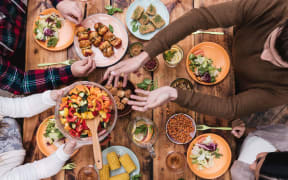 Friends having dinner. Top view of four people having dinner together while sitting at the rustic wooden table