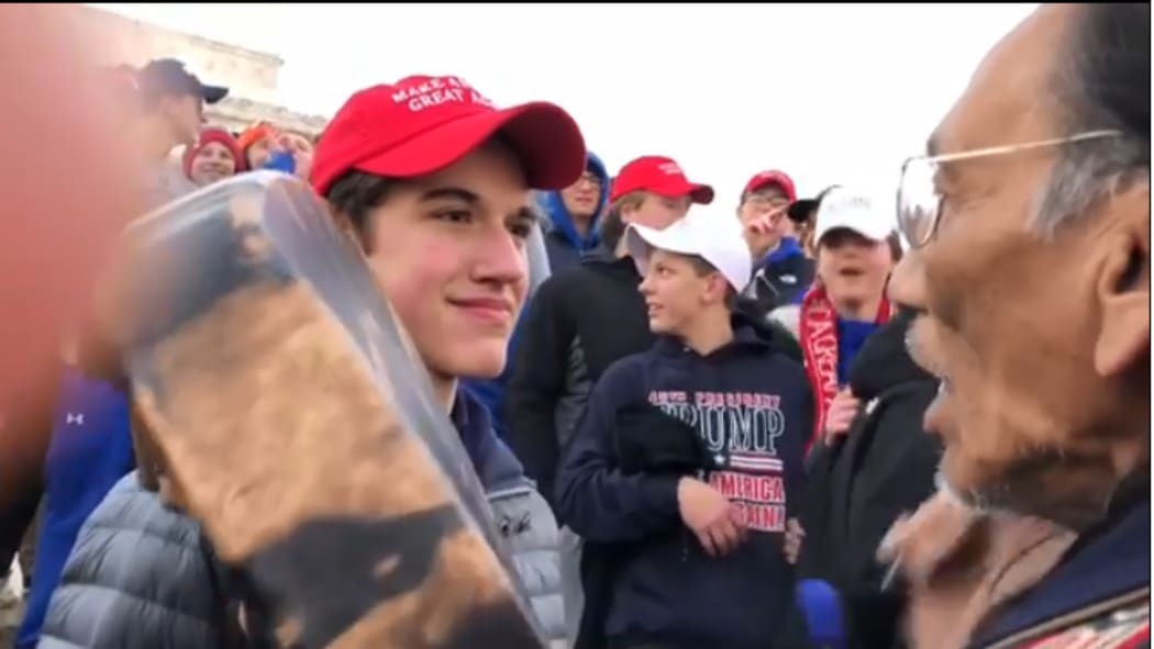 Student Nick Sandmann stands close staring at Omaha elder Nathan Phillips.