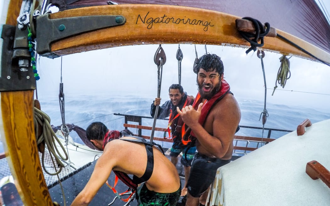 The crew of Hikianalia during a tropical downpour.