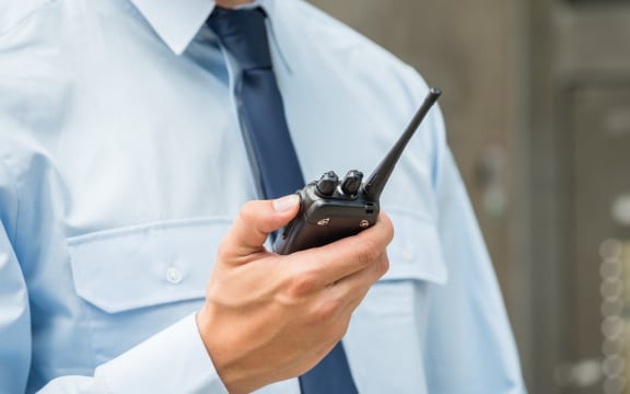 Security Guard Holding Walkie-talkie.