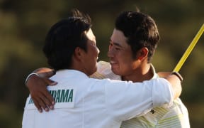 AUGUSTA, GEORGIA - APRIL 11: Hideki Matsuyama of Japan hugs his caddie, Shota Hayafuji, on the 18th green after winning the Masters at Augusta National Golf Club on April 11, 2021 in Augusta, Georgia.