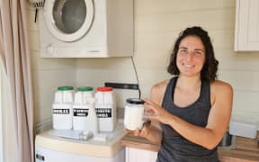Sonja Barrish in her laundry with the borax, washing soda and baking soda she uses in her homemade cleaning products.