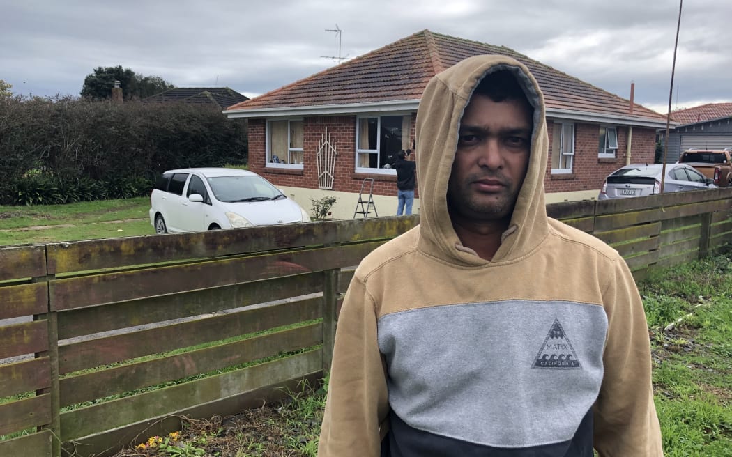 Abinesh Kumar stands in front of his flat in Manukau.