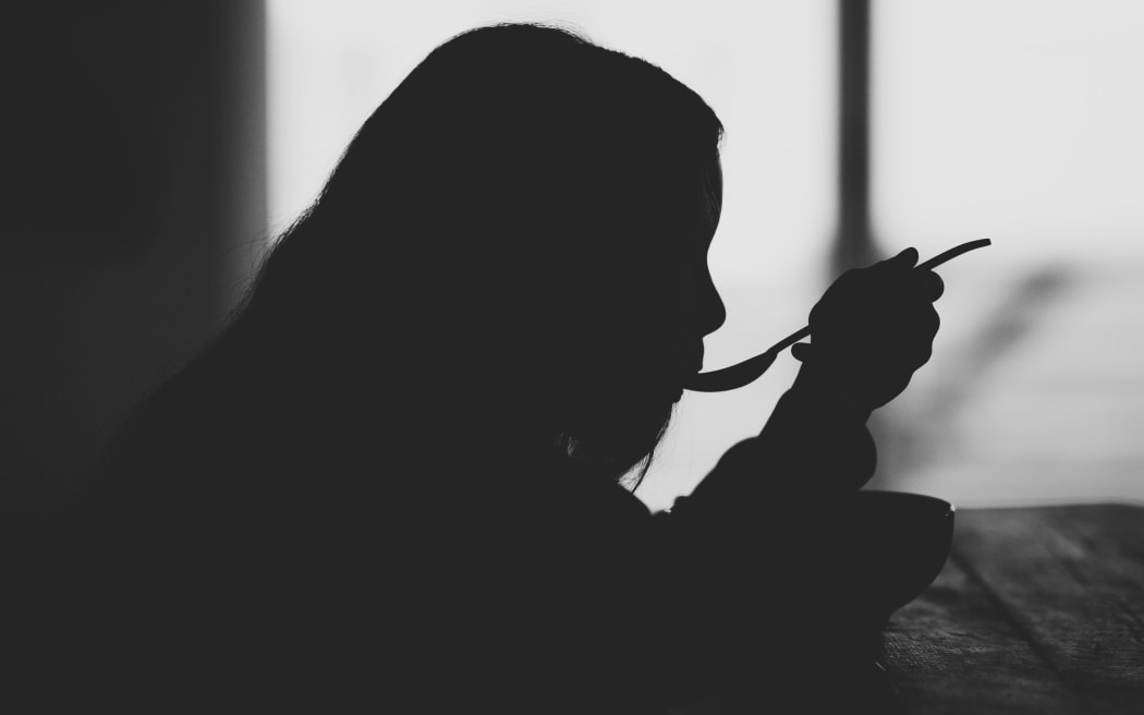 woman eating in silhouette