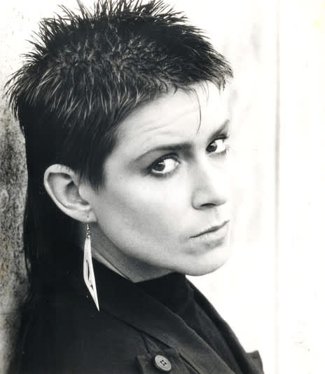 Shona Laing has short spiky hair, a long earing and a challenging gaze.