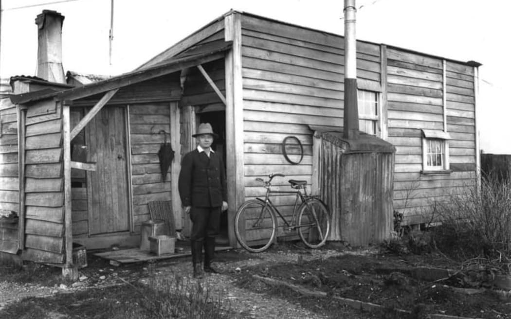 The photographer Jos Divis outside his Waiuta residence, circa 1930.